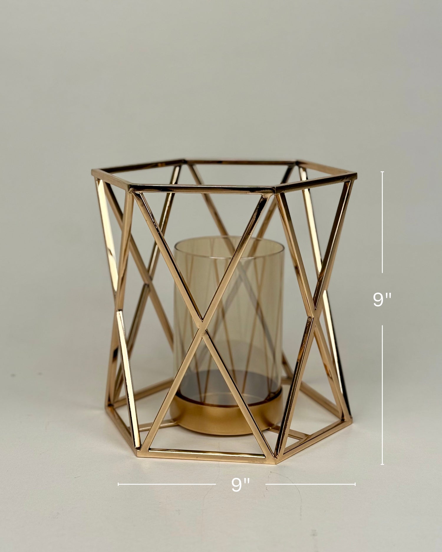 High Objects Gilded Prism Candle Stand with gold-finished geometric frame and amber glass holder.