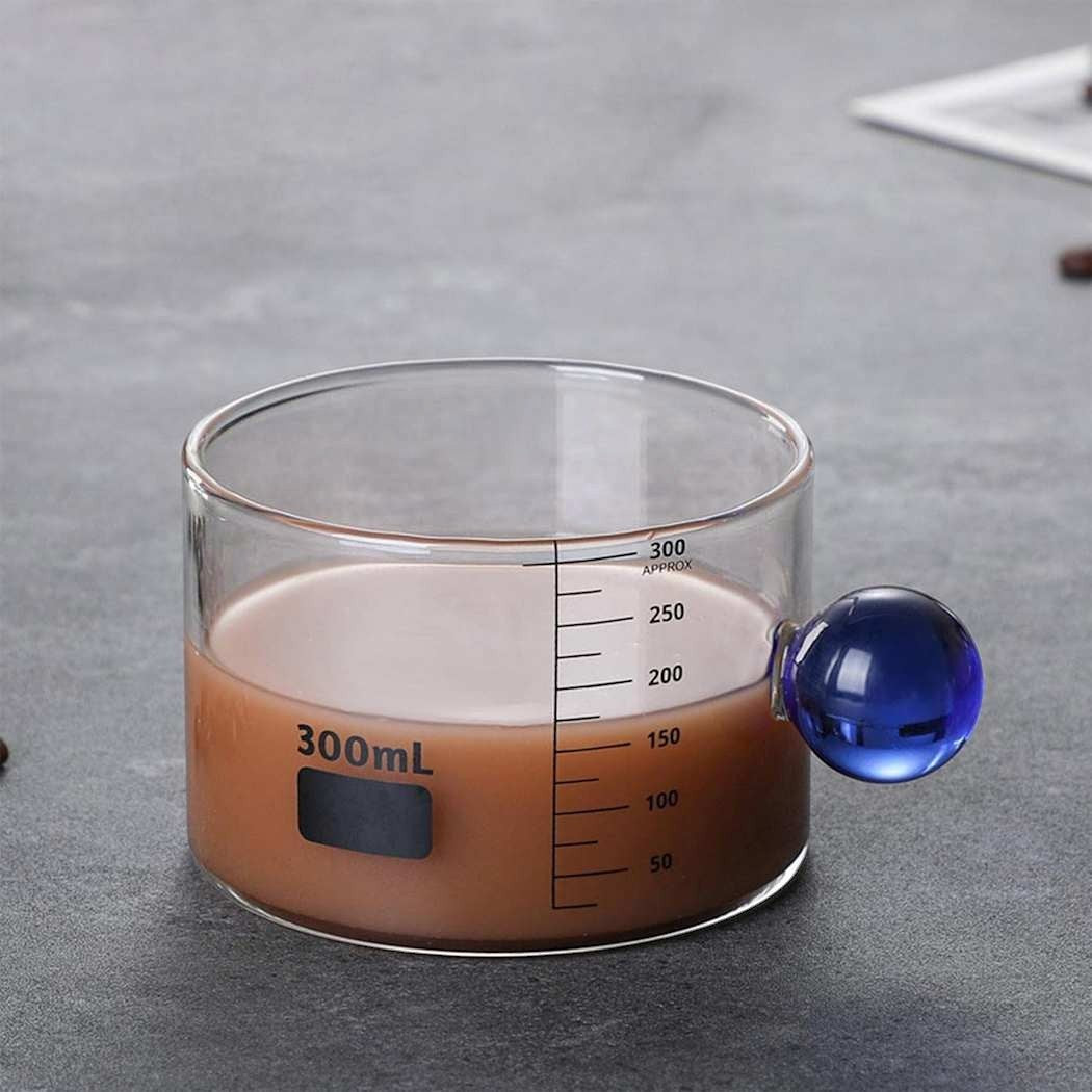 High Objects clear borosilicate glass cup with blue orb handle and 300ml measurement markings.