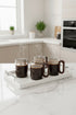 High Objects OBLIQ glass cups with dark wood handles, set of 4, filled with steaming coffee on a white tray.