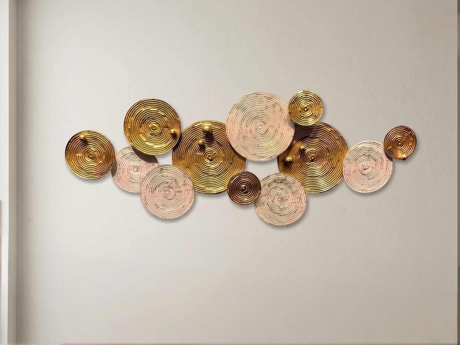 High Objects modern wall art featuring a cluster of metallic gold and textured beige circular discs on a wall.