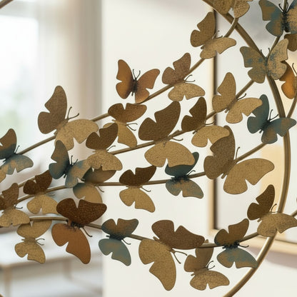 High Objects gold metal circular sculpture with a branch of butterflies in gold, bronze, and blue hues.