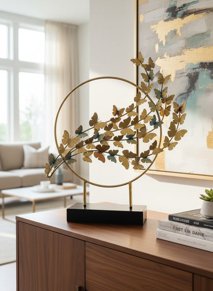 High Objects gold metal showpiece with a circular frame and a cluster of butterflies in varying sizes and shades of gold and blue.