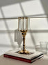 High Objects gold metal and clear glass candle stand with faceted hurricane top and pedestal base.