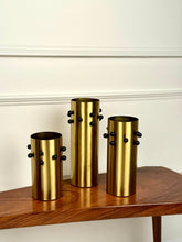 High Objects set of 3 gold metal vases with black studs, cylindrical shape, brushed finish.