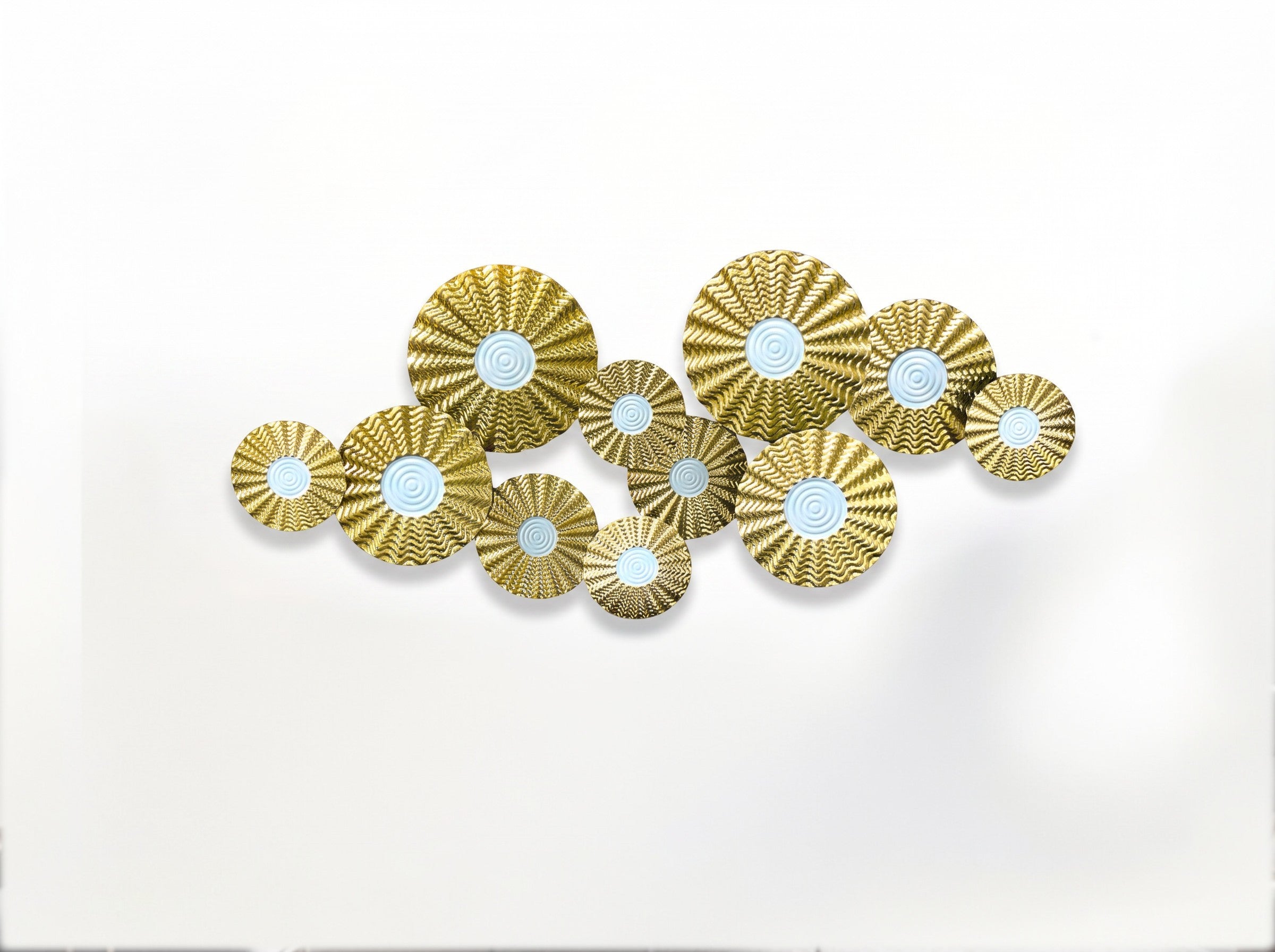 High Objects gold metal wall art featuring a cluster of textured circular discs with white centers in a modern living room
