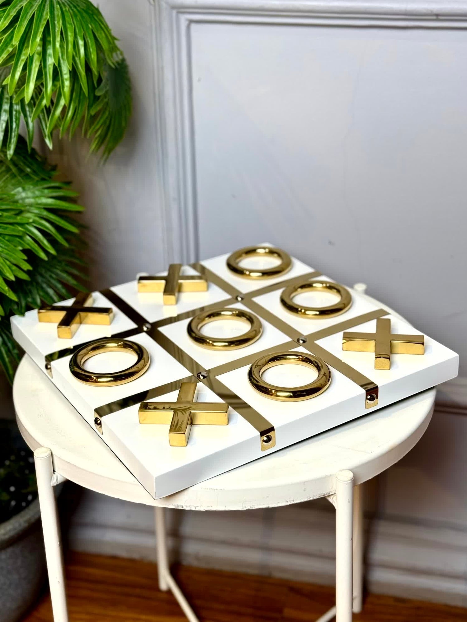 High Objects Gold Tic-Tac-Toe Set with white MDF base and gold-tone iron X and O pieces. Modern luxury decor.