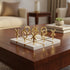 High Objects Sculpted Gold Tic-Tac-Toe Set with gold X and O pieces on a white board, a decorative game.