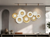 High Objects decorative wall art featuring overlapping white and gold circular textured discs in a modern living room.