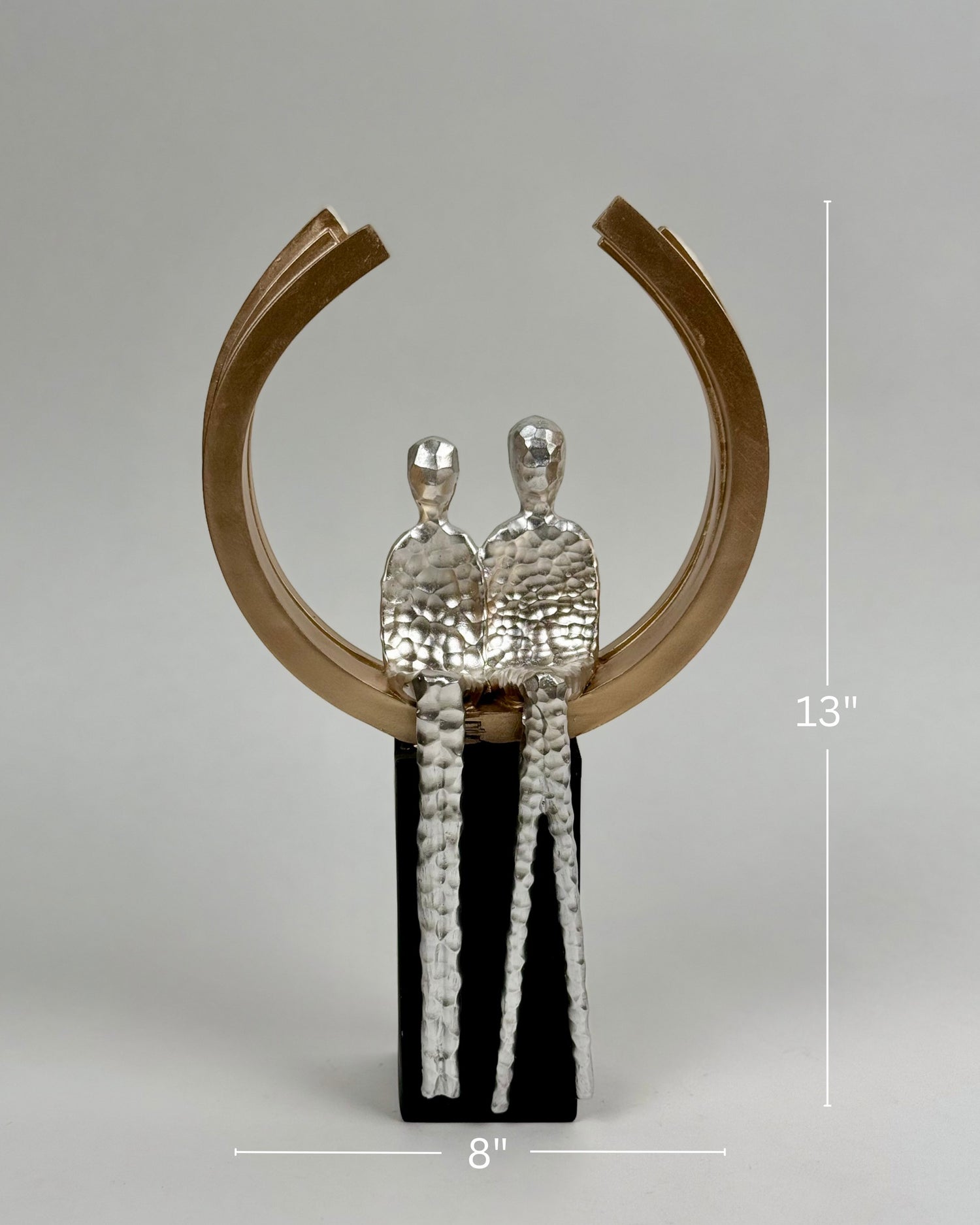 High Objects Golden Arc of Love showpiece with hammered silver couple inside a gold ring on a black base.