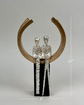 High Objects Golden Arc of Love showpiece with hammered silver couple inside a gold ring on a black base.