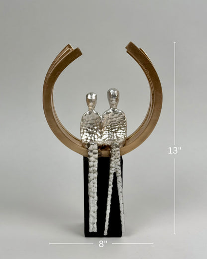 High Objects Golden Arc of Love showpiece with hammered silver couple inside a gold ring on a black base.