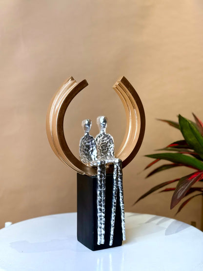 High Objects Golden Arc of Love showpiece, abstract couple in hammered silver finish within a gold ring on a black base.