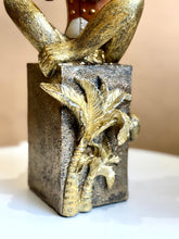 High Objects Golden Serenade Monkey Showpiece, gold polyresin monkey playing flute, vintage coat and top hat, textured pedestal with palm trees.