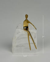 High Objects Golden Poise abstract sculpture of a seated figure on a natural crystal base, gold-finished iron.