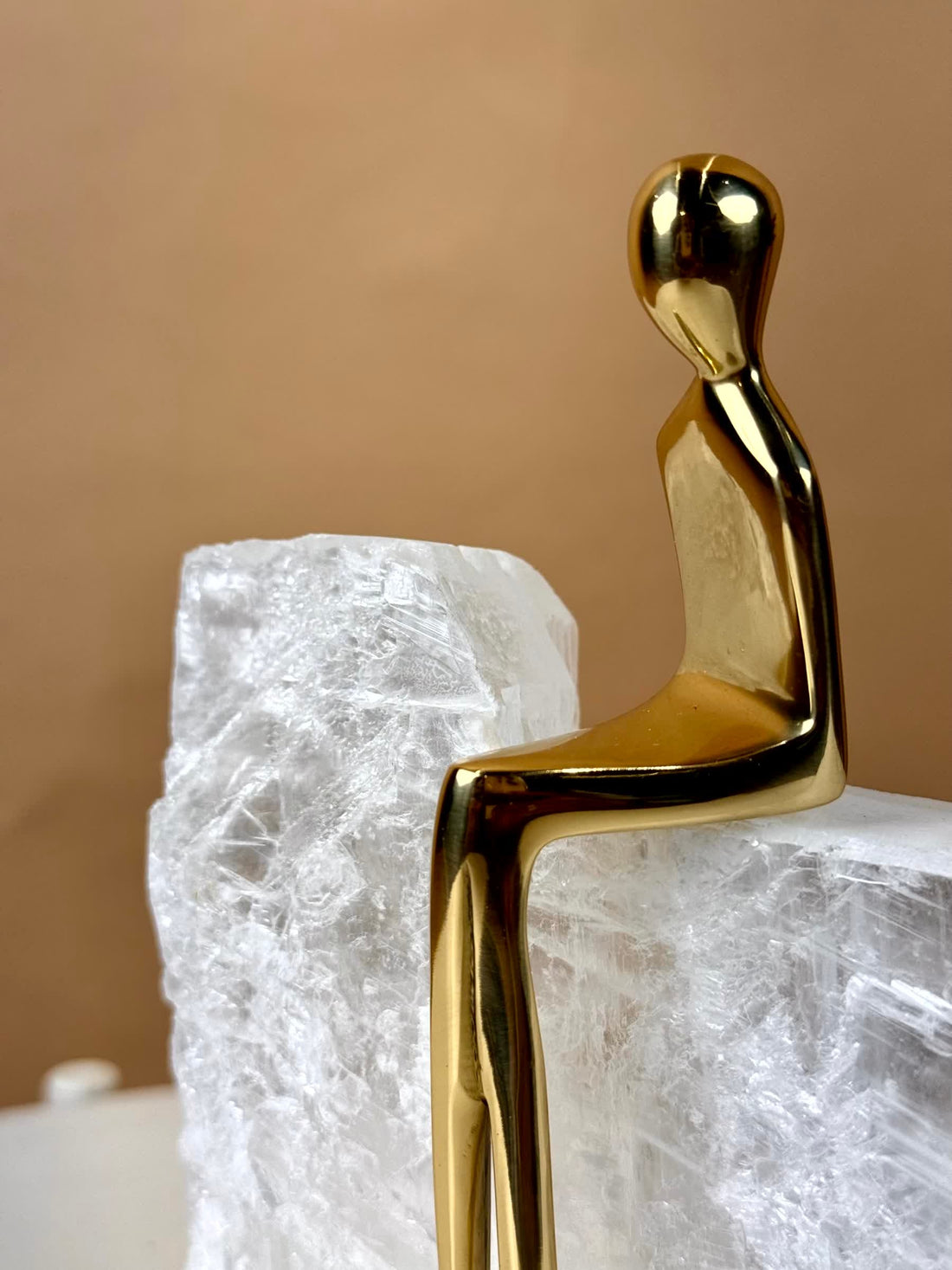 High Objects Golden Poise abstract figure sculpture on natural crystal base, polished gold-finished iron.