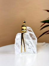 High Objects Golden Poise abstract sculpture of a figure in polished gold-finished iron on a natural crystal base.