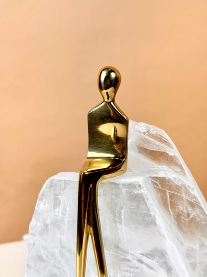 High Objects Golden Poise abstract figure sculpture in polished gold-finished iron on a natural crystal base.