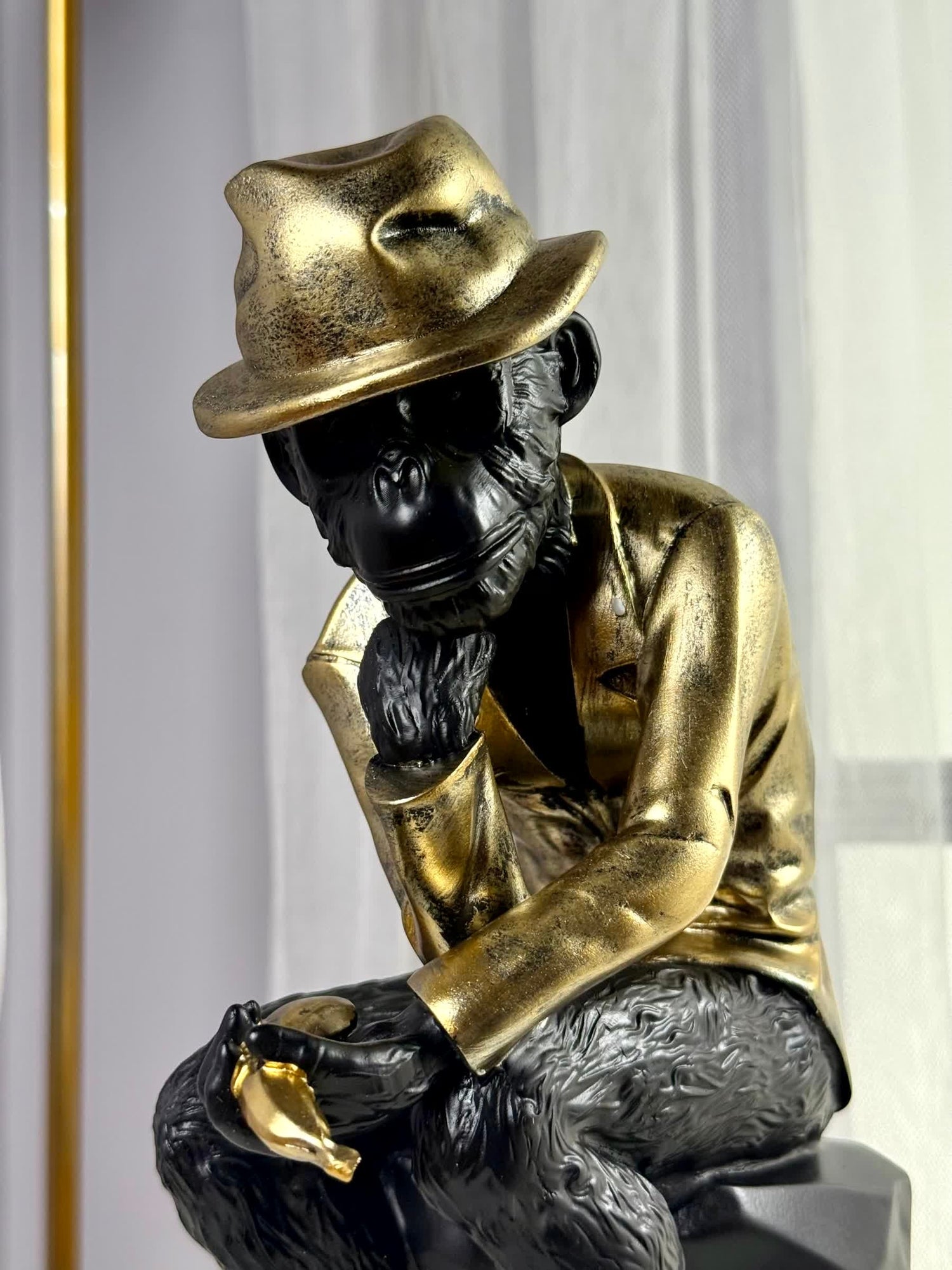 High Objects Golden Thinker Showpiece, a black polyresin monkey in a metallic gold suit and fedora, in a thoughtful pose.