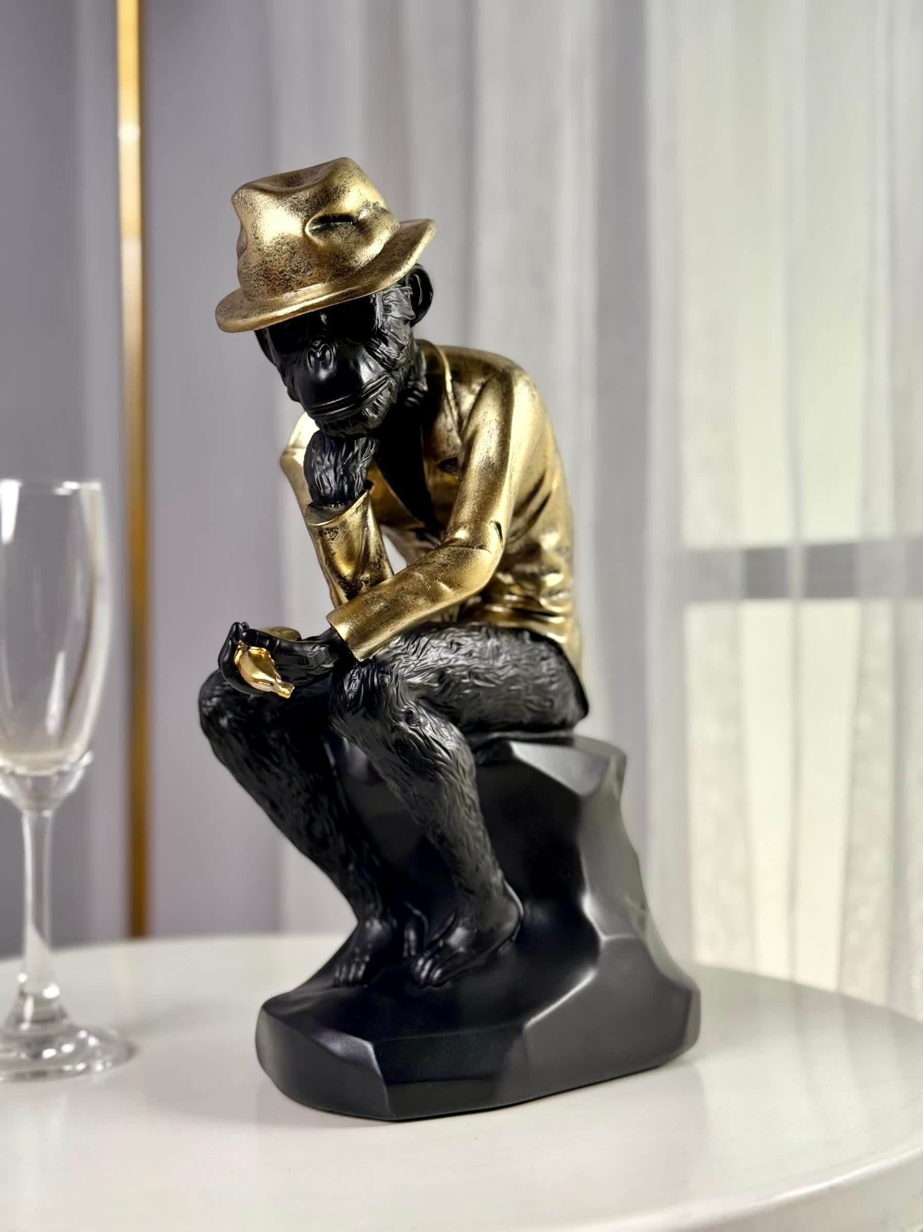 High Objects Golden Thinker Showpiece, a polyresin monkey in a metallic gold suit and fedora, in a thoughtful pose on a black base.
