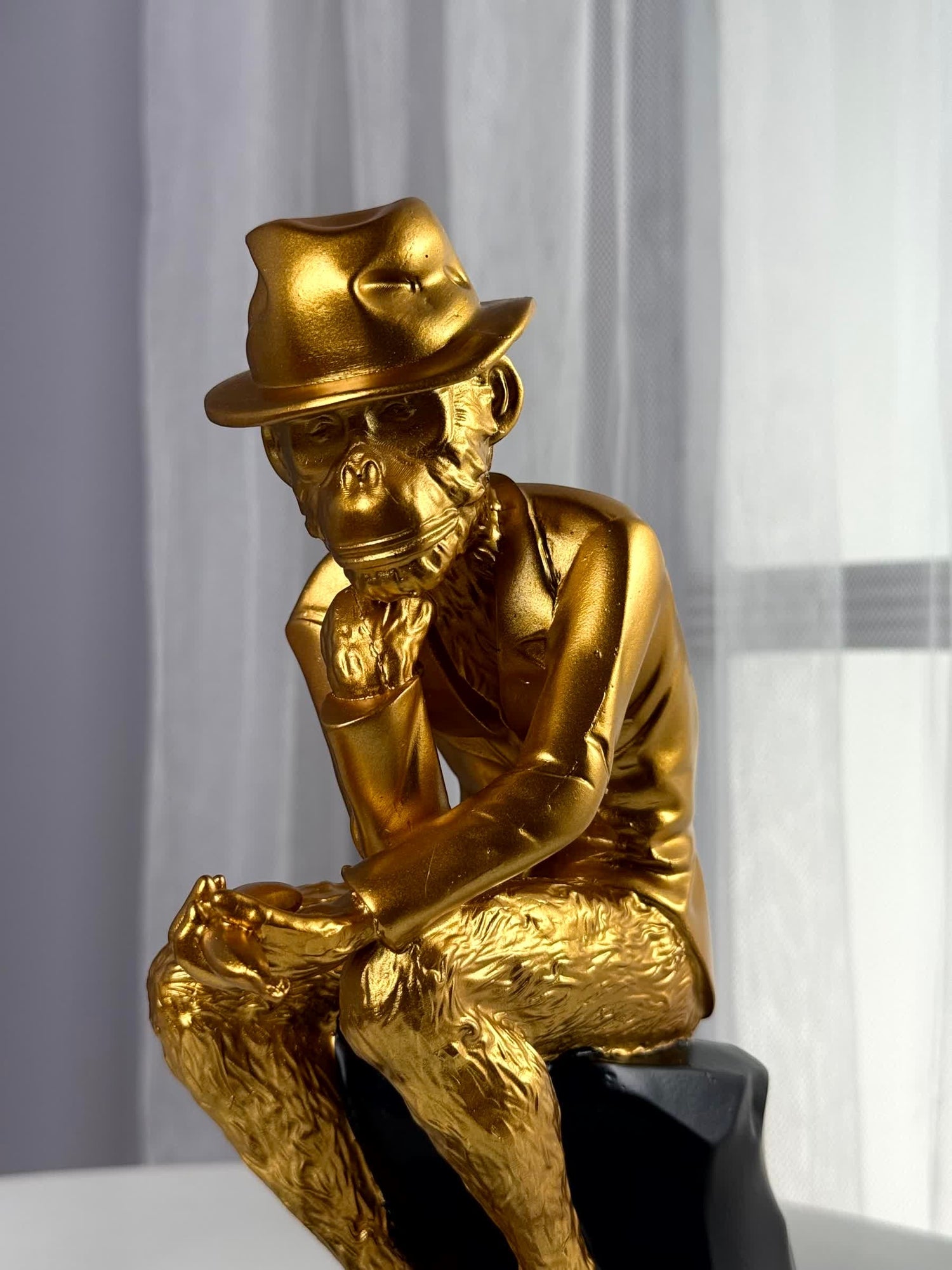 High Objects Golden Thinker Showpiece, a gold polyresin monkey figurine in a thoughtful pose wearing a fedora and suit, on a black base.