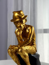 High Objects Golden Thinker Showpiece, a gold polyresin monkey figurine in a thoughtful pose wearing a fedora and suit, on a black base.
