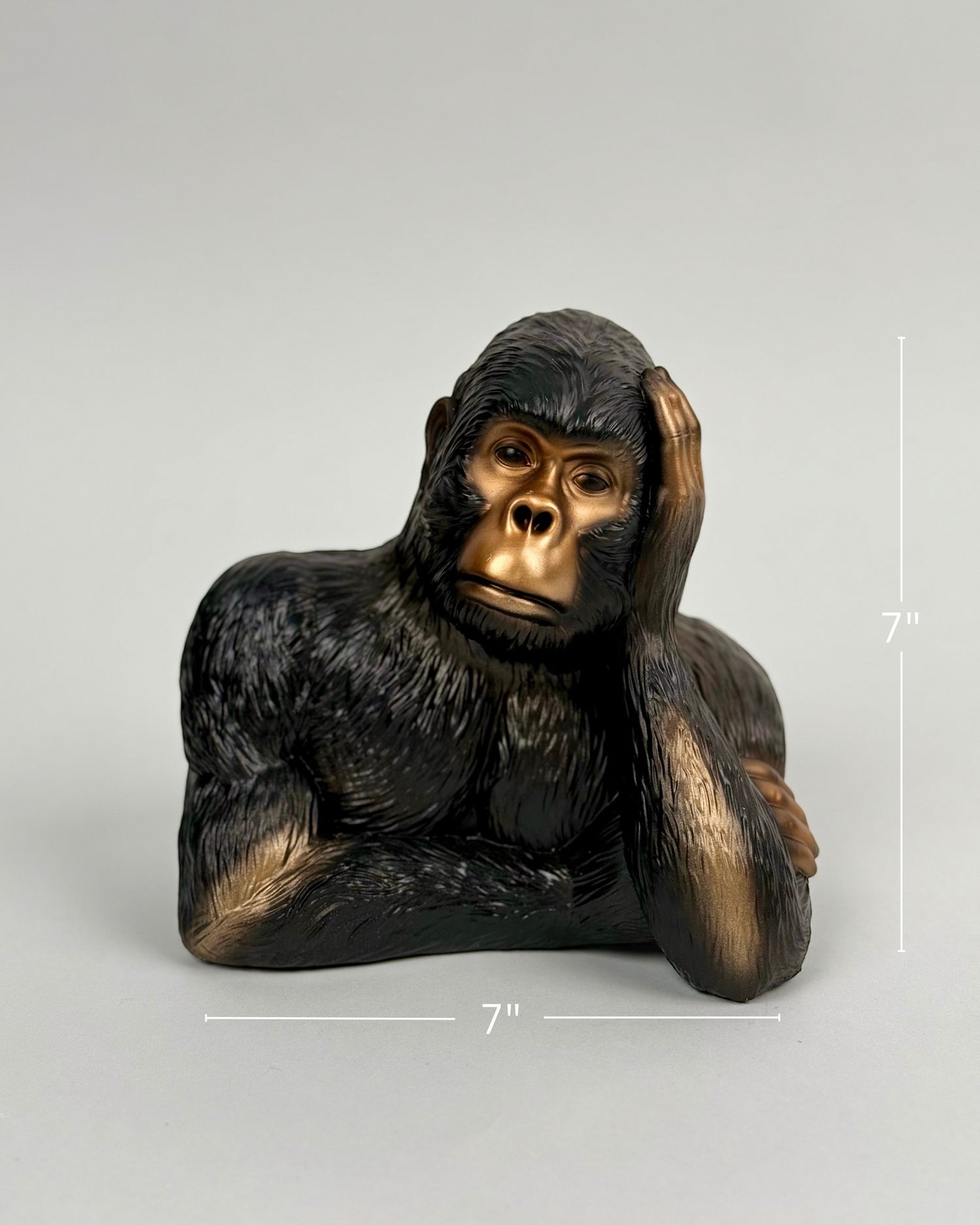 High Objects Pensive Gorilla showpiece sculpture with a golden face and dark textured body, resting head on hand.