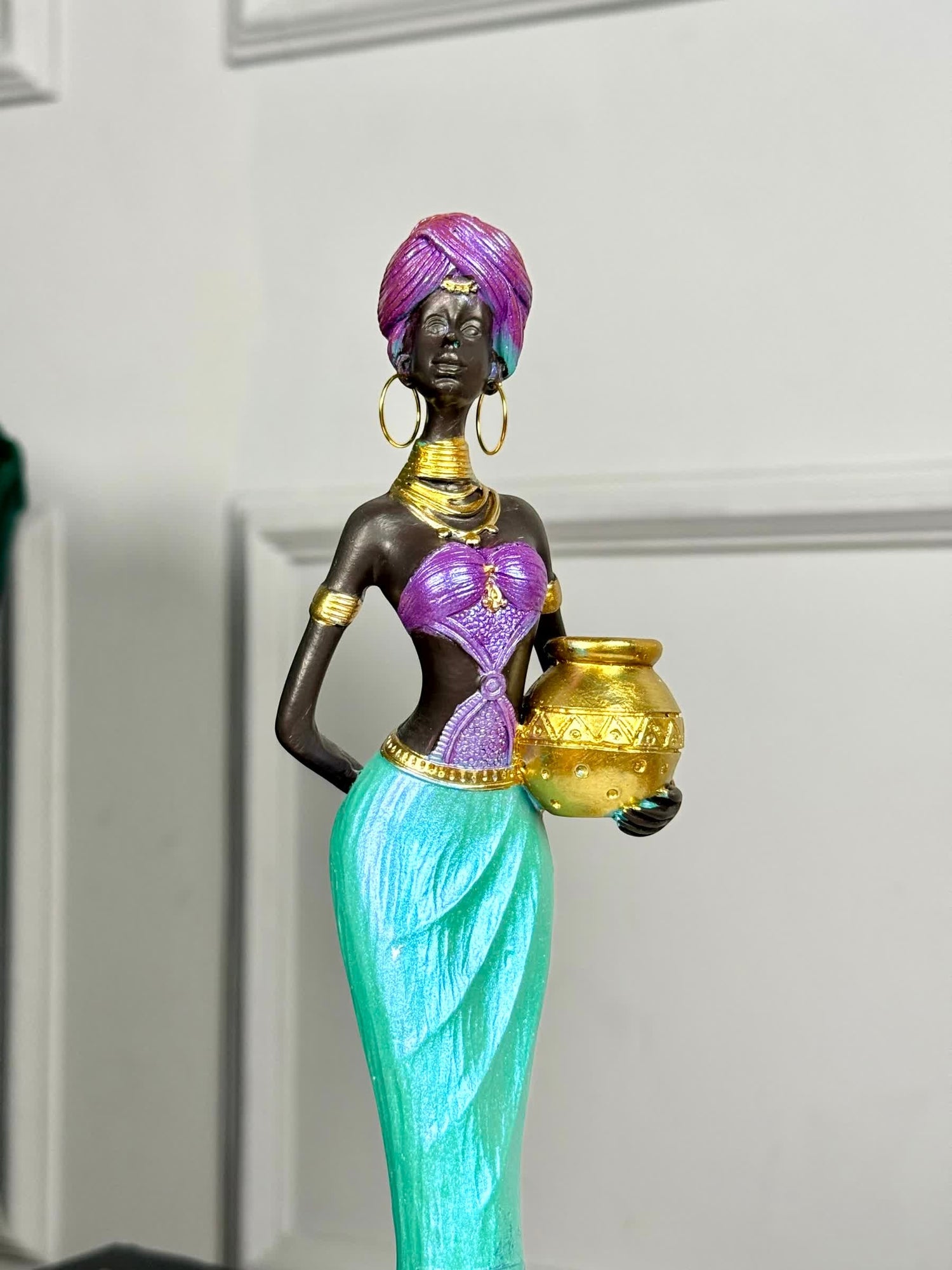 High Objects Grace of the Nile showpiece: African woman sculpture in purple and turquoise attire holding a golden pot. 12-inch polyresin.