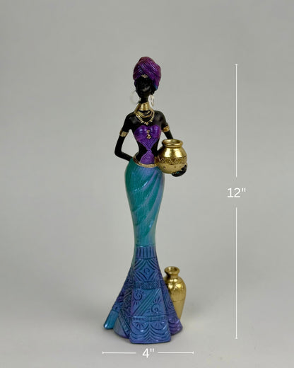 High Objects Grace of the Nile showpiece, 12-inch polyresin sculpture of an African woman in purple and turquoise traditional attire holding a golden pot.