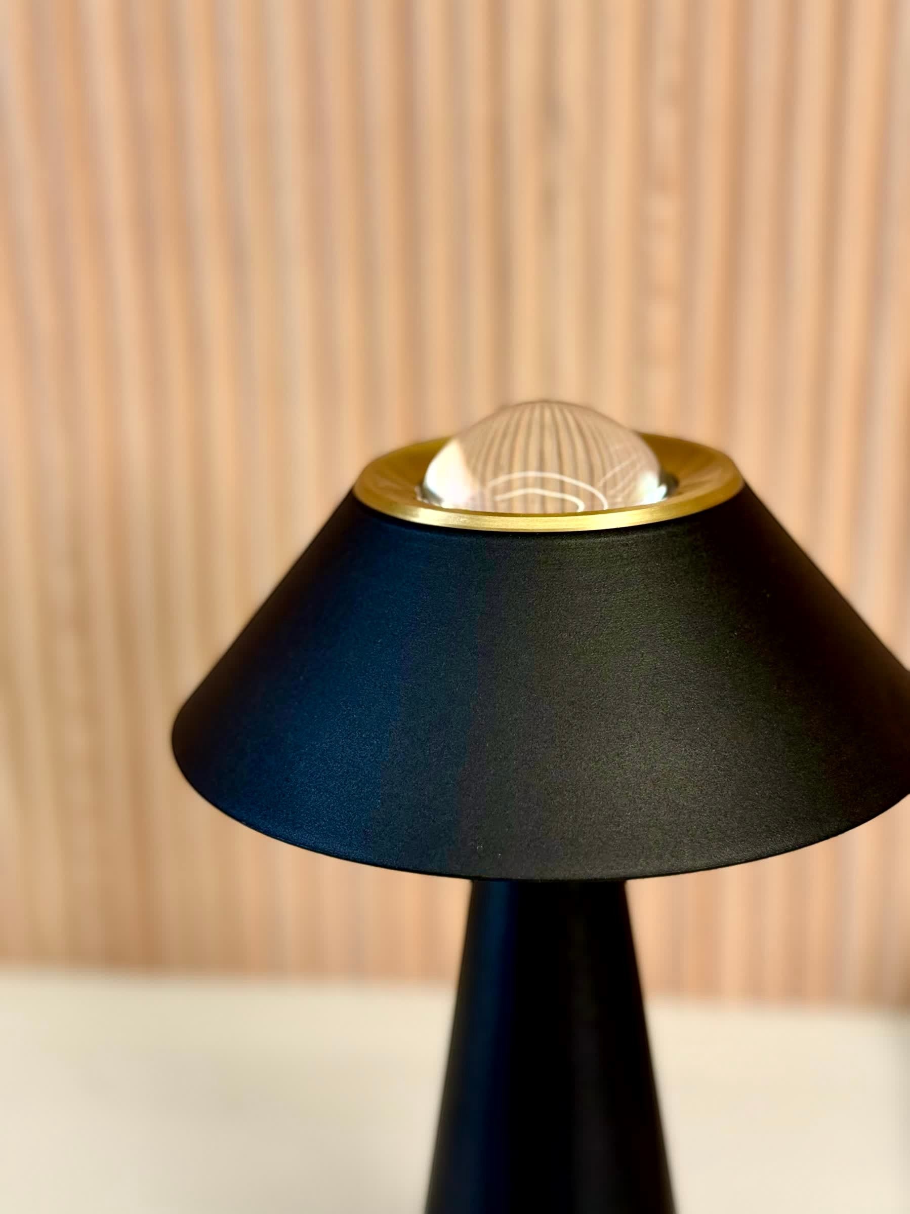 High Objects Halo Noir Table Lamp in matte black with gold accent and clear glass dome top. Minimalist design.