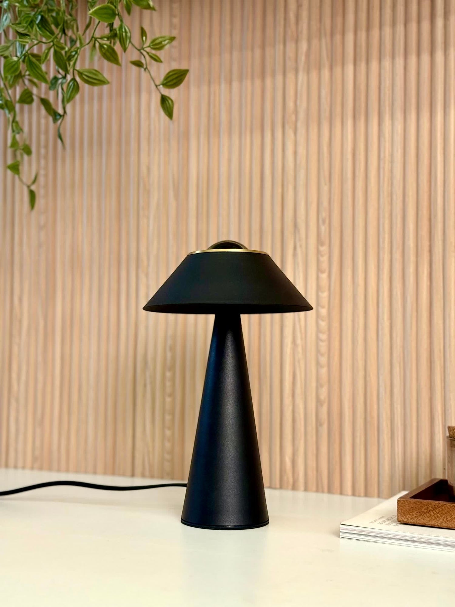 High Objects Halo Noir Table Lamp, matte black conical base with flared shade and gold accent, modern minimalist design.