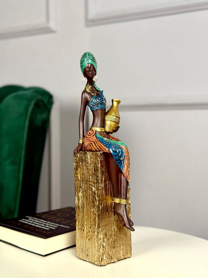 High Objects Heritage Grace showpiece: tribal woman in colorful attire holding a gold pot, made of polyresin.