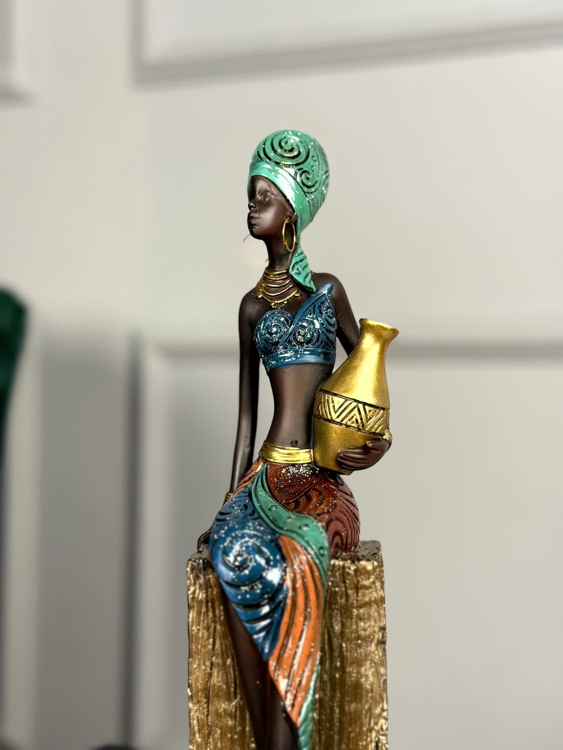 High Objects Heritage Grace showpiece: tribal woman sculpture in polyresin, holding a gold pot. Hand-painted attire in blue, green, orange.