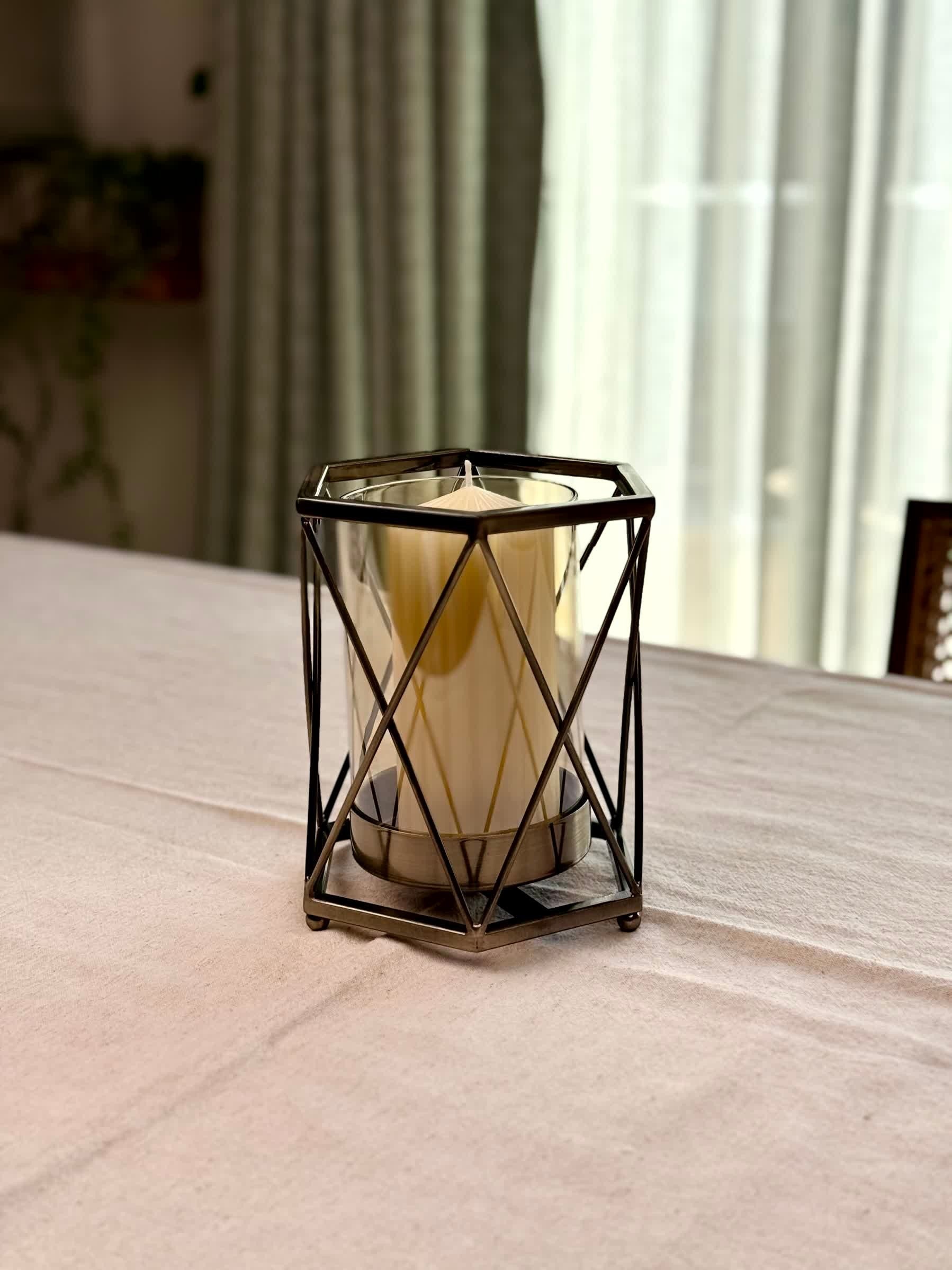 High Objects Hexagrid Candle Stand with geometric metal frame and glass cylinder holding a cream pillar candle.