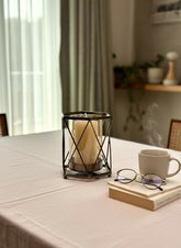 High Objects Hexagrid Candle Stand with geometric metal frame and glass cylinder holding a cream pillar candle.