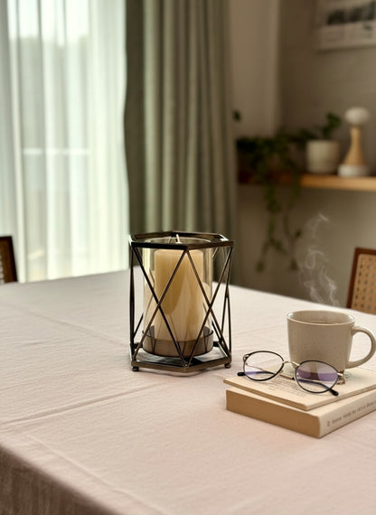 High Objects Hexagrid Candle Stand with geometric metal frame and glass cylinder holding a cream pillar candle.