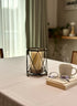 High Objects Hexagrid Candle Stand with geometric metal frame and glass cylinder holding a cream pillar candle.