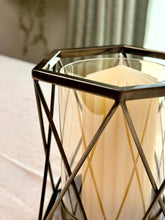 High Objects Hexagrid Candle Stand with a cream candle inside a geometric metal frame and glass cylinder.