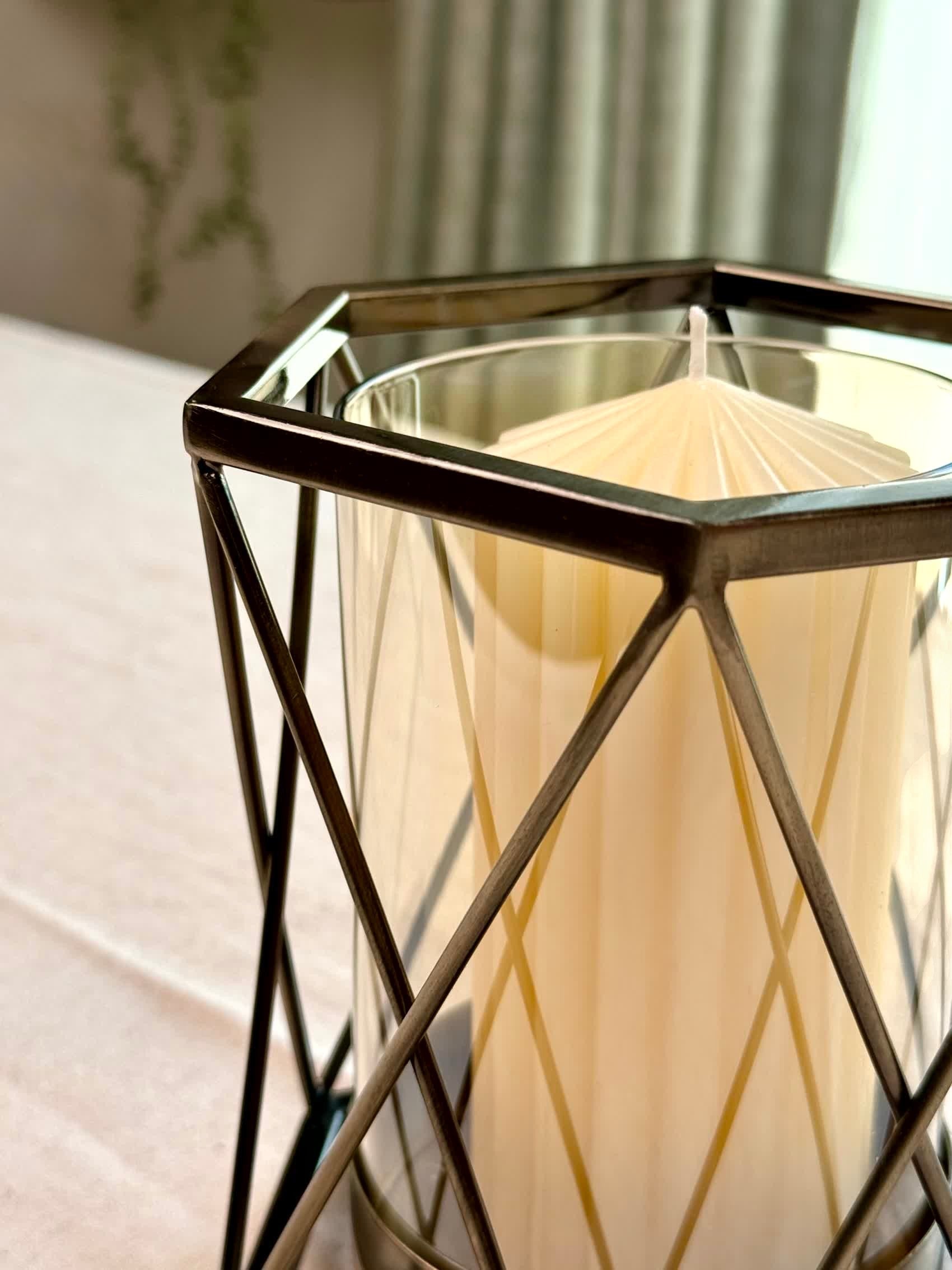 High Objects Hexagrid Candle Stand with a cream candle inside a geometric metal frame and glass cylinder.