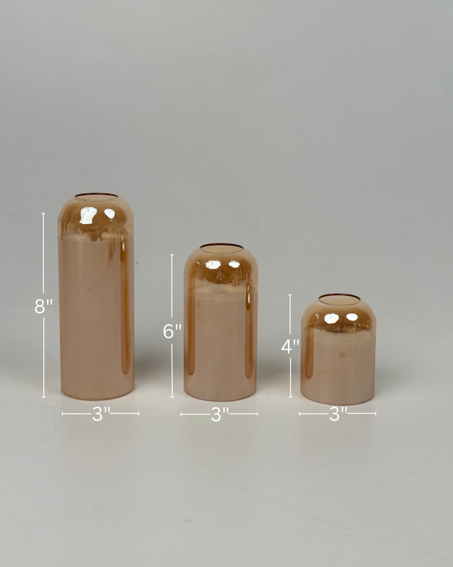 High Objects set of 3 iridescent glass vases in champagne and amber tones. Modern cylinder and bell shapes.