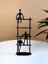 High Objects Journey Ladder Artefact, matte black iron sculpture with three abstract figures climbing a ladder, symbolizing progress and teamwork.