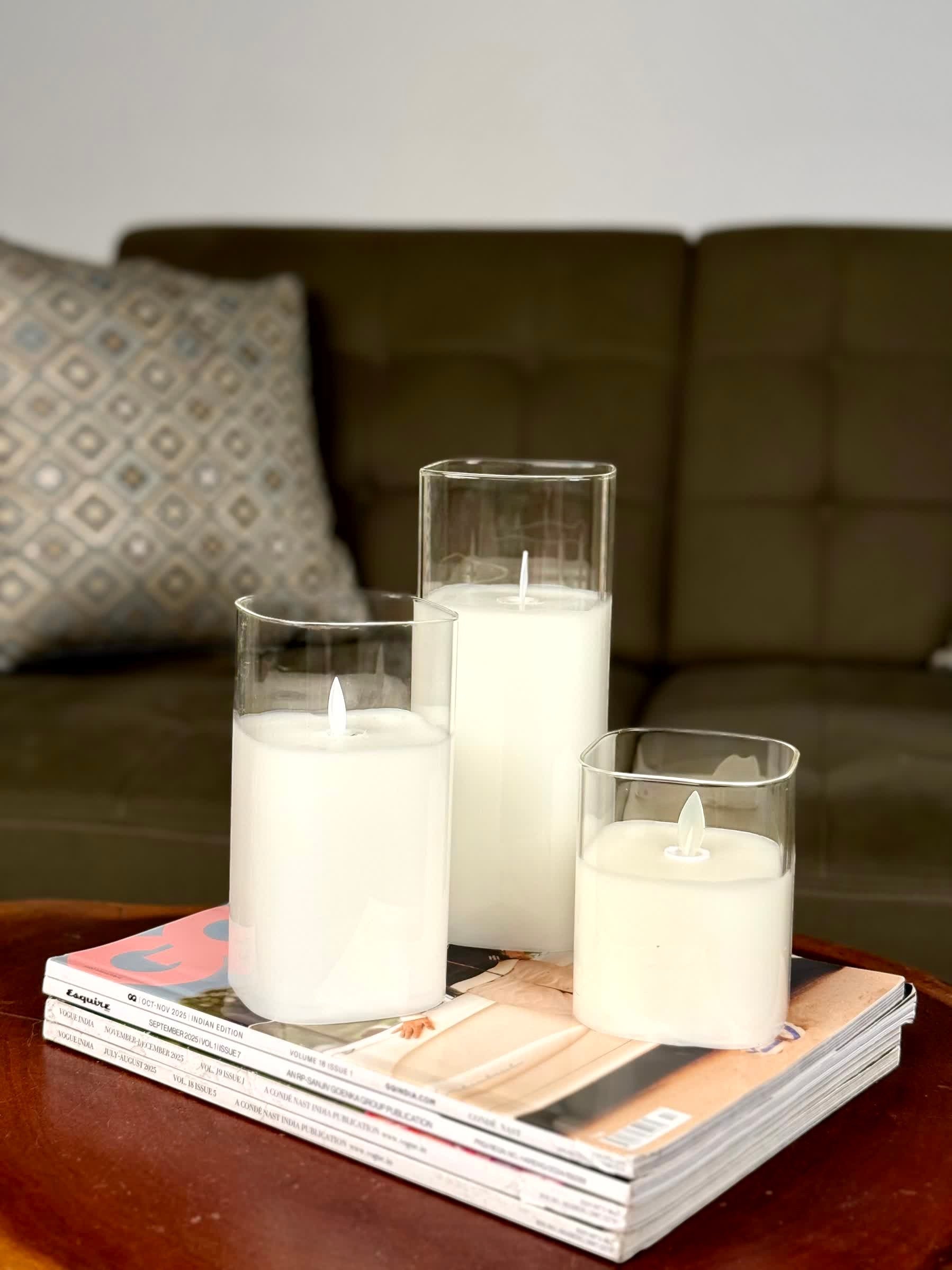 High Objects Halomist LED Candle Collection: Set of 3 white LED candles in clear glass holders on magazines. Modern decor.