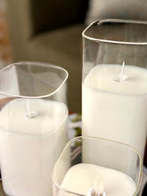 High Objects Halomist LED candles in white wax with clear glass cylinders, featuring modern rounded square and cylindrical shapes.