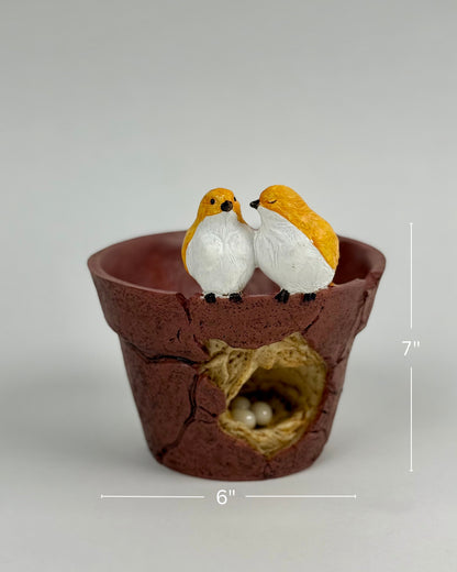 High Objects Lovebird Planter Showpiece, rustic brown polyresin pot with cracked design, featuring two yellow and white lovebirds on the rim and a nest with eggs inside.