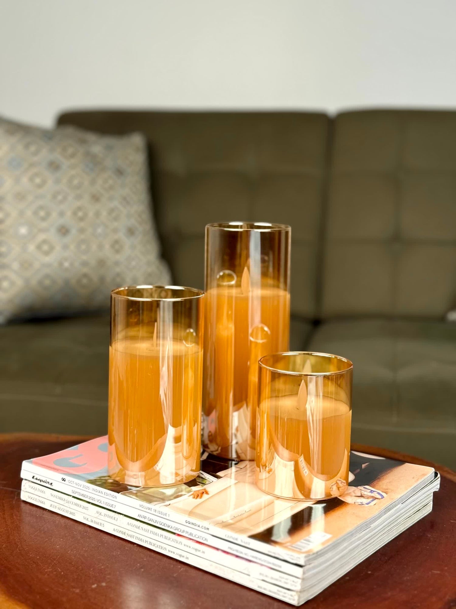 High Objects Lumiglass LED candles in amber glass cylinders, flickering LED flames, set of 3 on magazines.