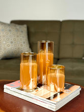 High Objects Lumiglass LED candles in amber glass cylinders, flickering LED flames, set of 3 on magazines.
