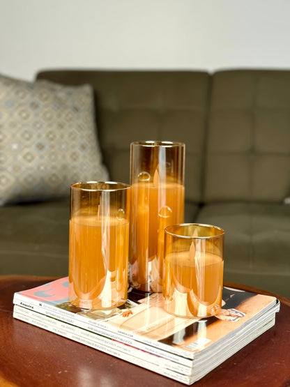 High Objects Lumiglass LED candles in amber glass cylinders, flickering LED flames, set of 3 on magazines.