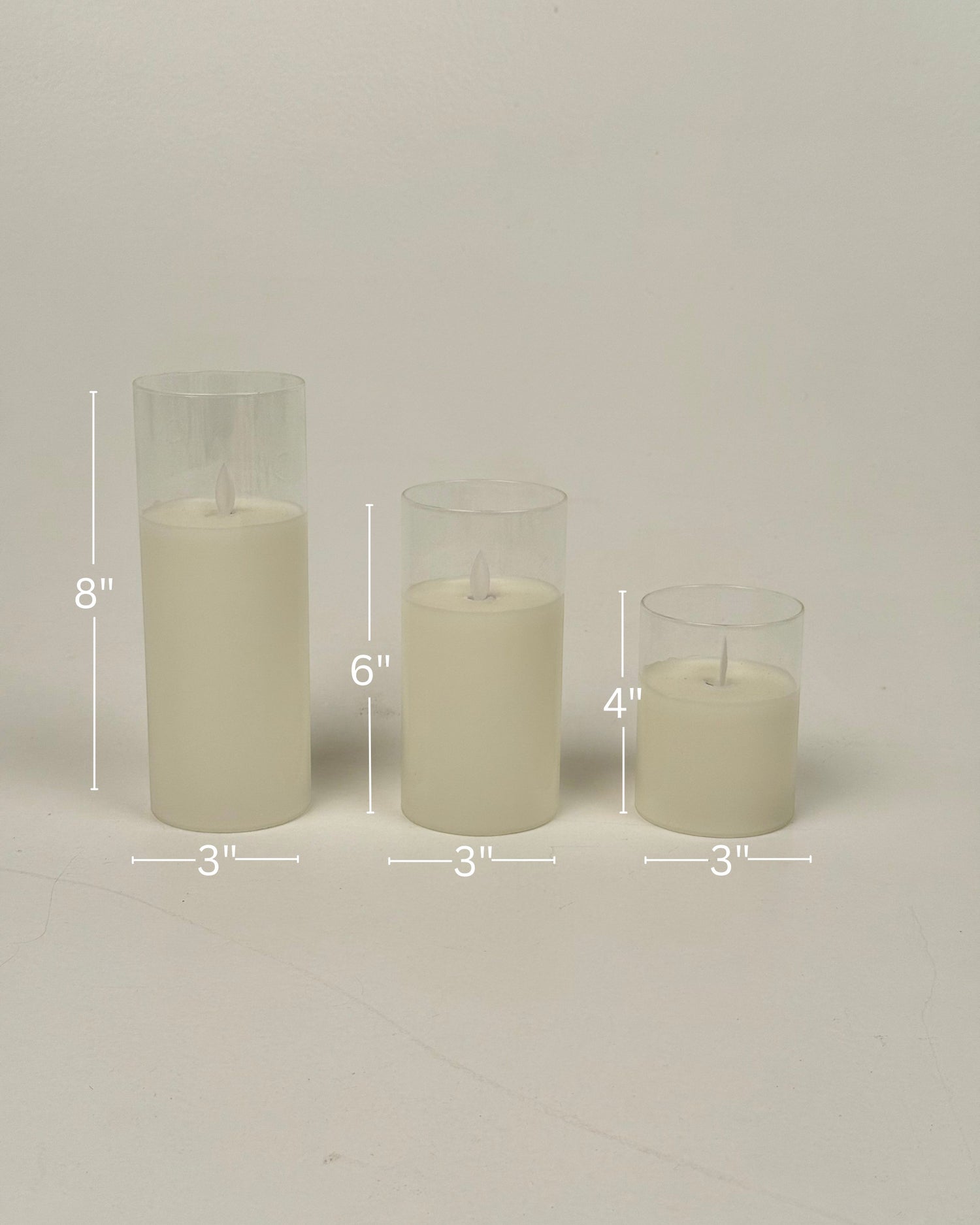 High Objects Lumiglass LED Candle Collection: set of 3 cream pillar candles in glass cylinders, 8", 6", 4" tall.