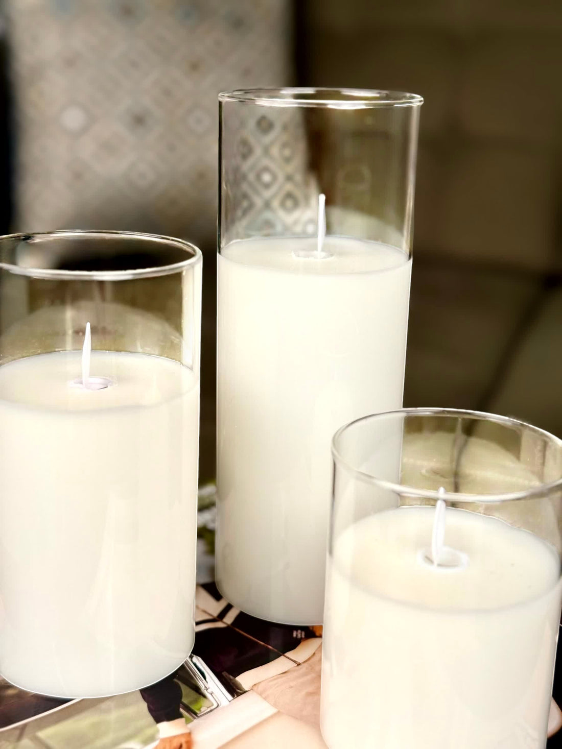 High Objects Lumiglass LED candles in clear glass cylinders, white pillar candles with wicks.