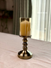 High Objects Luminaria Pedestal Candle Stand Set with tinted glass hurricane and metallic stem, antique brass finish.