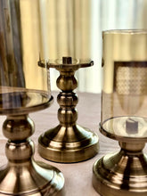 High Objects Luminaria Pedestal Candle Stand Set with tinted glass hurricanes and antique brass stems.